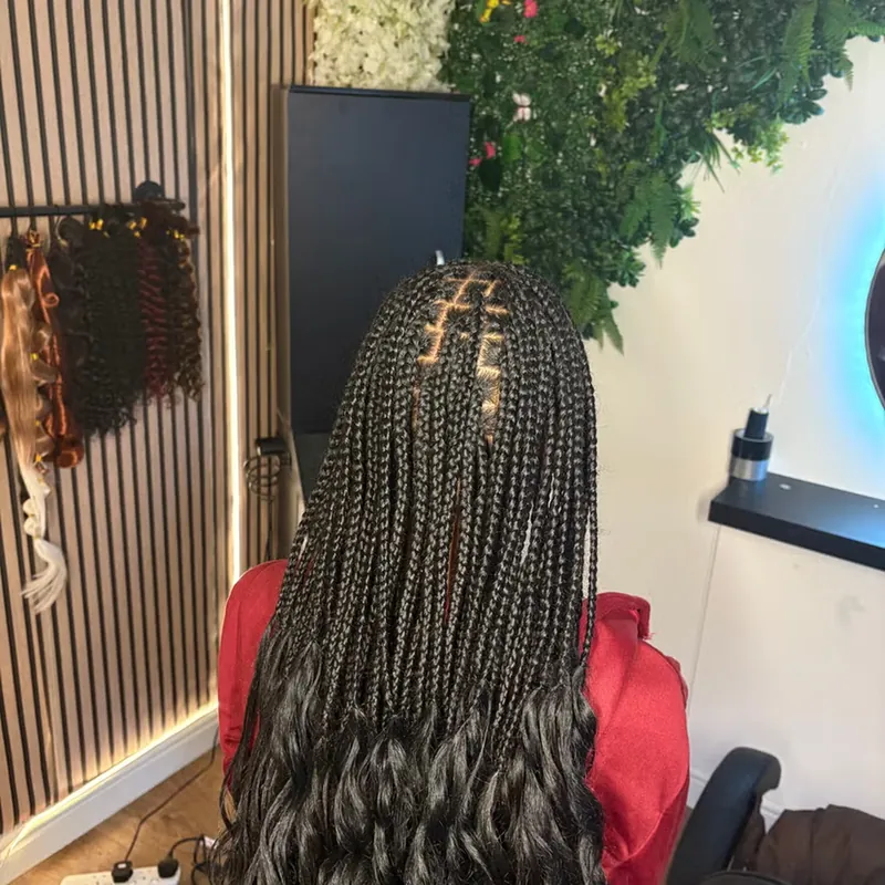 Waist-length knotless braids with curled ends, finished in the salon